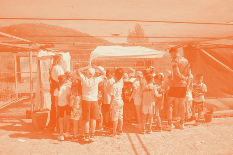 Grupo de escolares reunidos bajo una carpa antes de la aventura